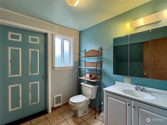 bathroom featuring tile patterned floors, toilet, a textured ceiling, and vanity