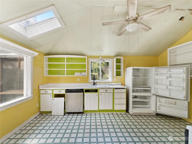 kitchen featuring lofted ceiling with skylight, stainless steel dishwasher, light floors, and refrigerator with glass door