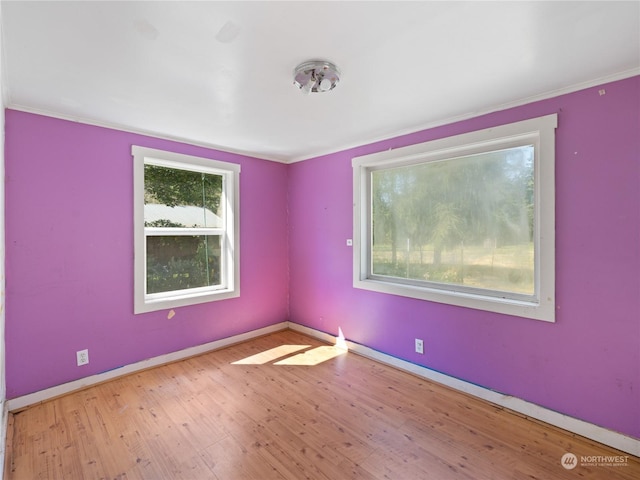 unfurnished room with hardwood / wood-style flooring and baseboards