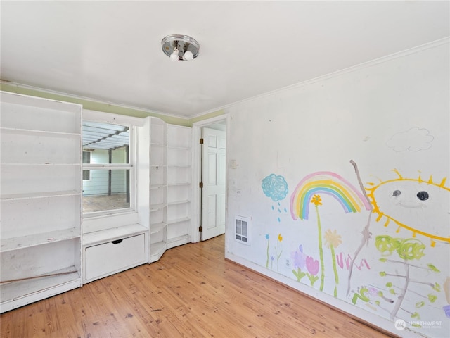 unfurnished bedroom with light wood-type flooring, visible vents, and ornamental molding