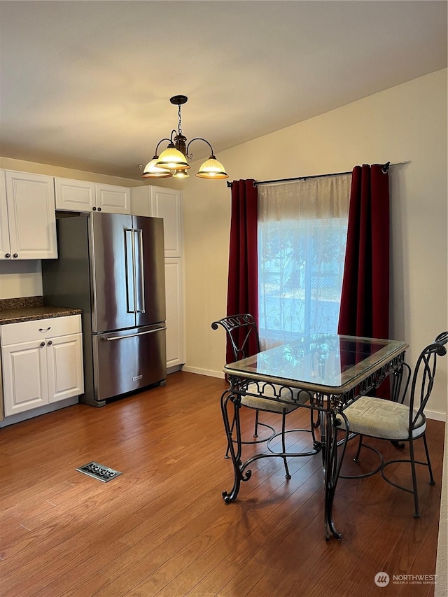 dining area featuring an inviting chandelier and wood-type flooring