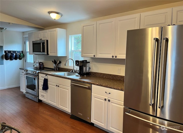 kitchen with stainless steel appliances, white cabinetry, sink, and dark hardwood / wood-style flooring