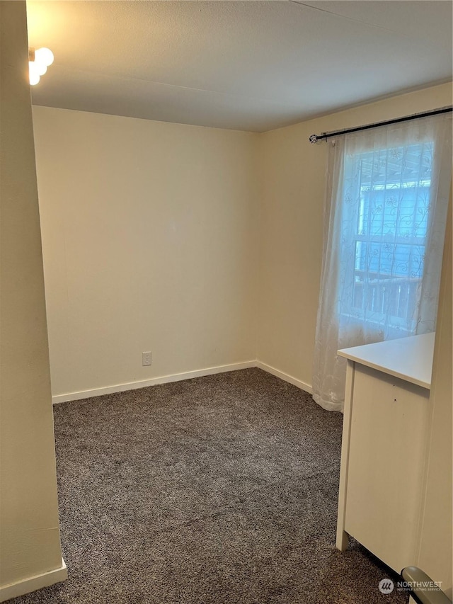 empty room with dark colored carpet