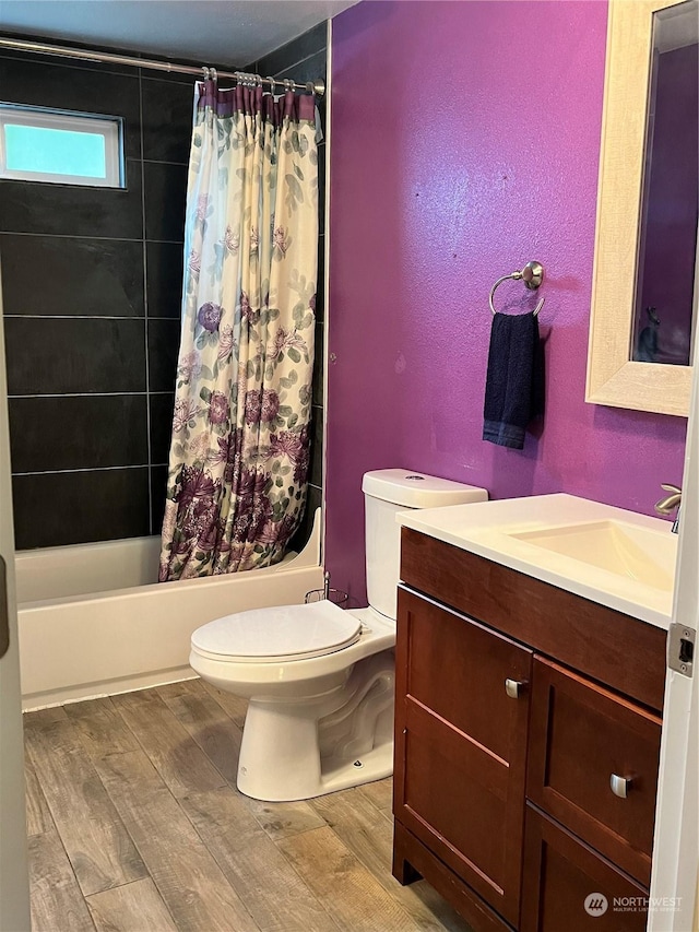 full bathroom featuring hardwood / wood-style flooring, shower / bath combo, vanity, and toilet