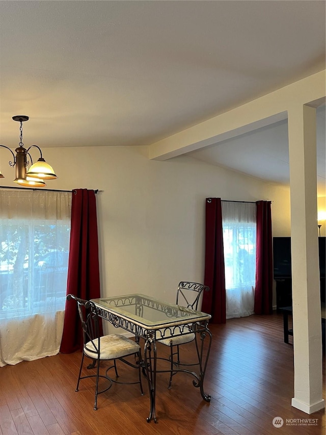 dining room with a chandelier, hardwood / wood-style floors, and beam ceiling