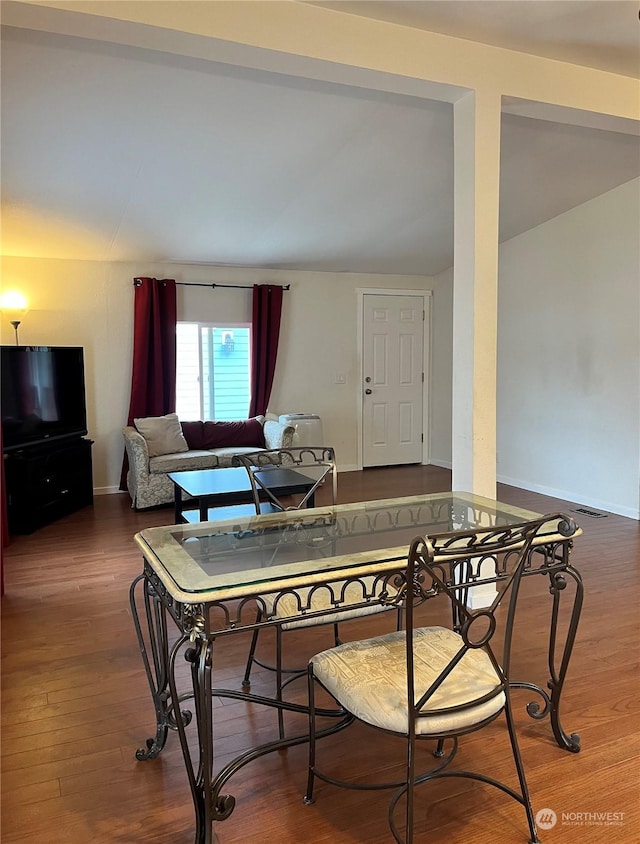 dining area featuring vaulted ceiling and hardwood / wood-style floors