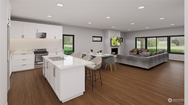 kitchen with range with electric cooktop, dark hardwood / wood-style flooring, an island with sink, black microwave, and sink