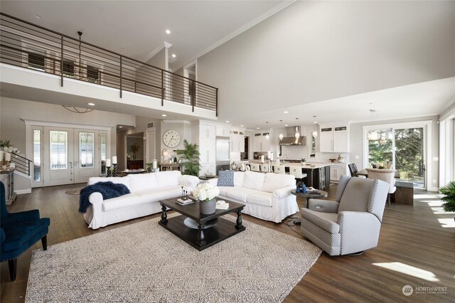 living room with ornamental molding, dark wood-type flooring, and a high ceiling