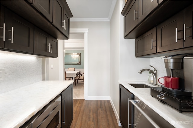 kitchen featuring dishwasher, dark brown cabinets, ornamental molding, dark hardwood / wood-style floors, and sink