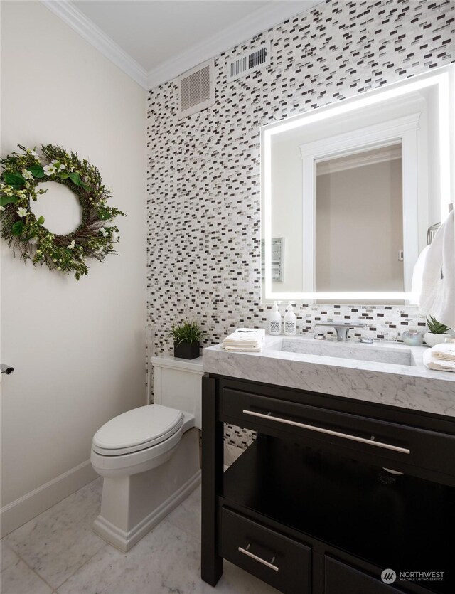 bathroom with vanity, toilet, crown molding, tile patterned flooring, and decorative backsplash