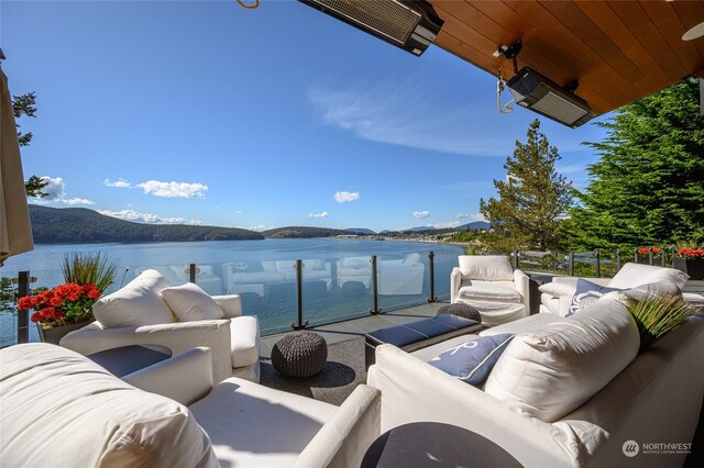 view of patio / terrace featuring a water and mountain view, a balcony, and outdoor lounge area