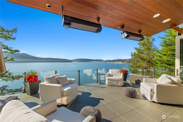 view of patio featuring a balcony, an outdoor hangout area, and a water and mountain view