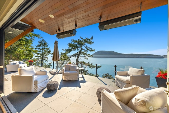 view of patio with a water view, an outdoor living space, and a wall mounted AC