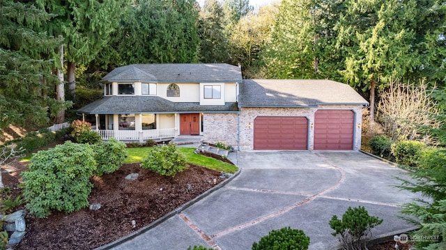 view of front of property with covered porch, concrete driveway, and a garage