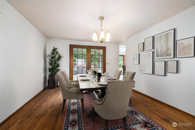 dining area with a notable chandelier, french doors, and dark wood-type flooring