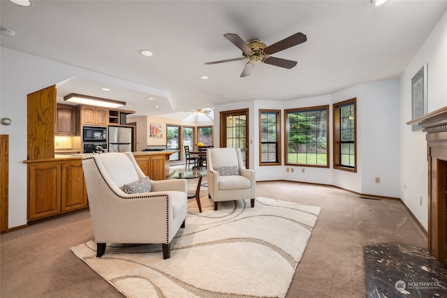 carpeted living room with ceiling fan