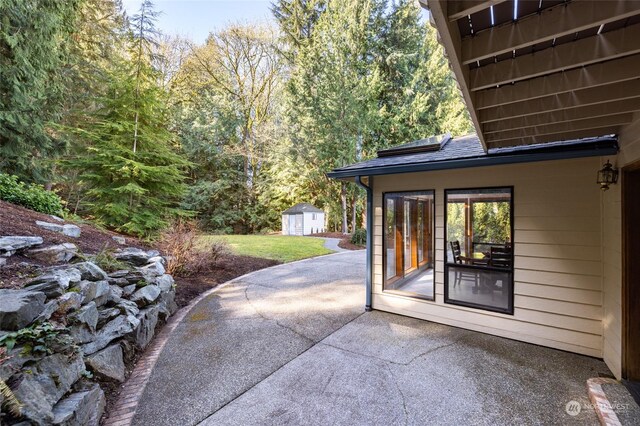 view of patio / terrace featuring an outdoor structure and a shed