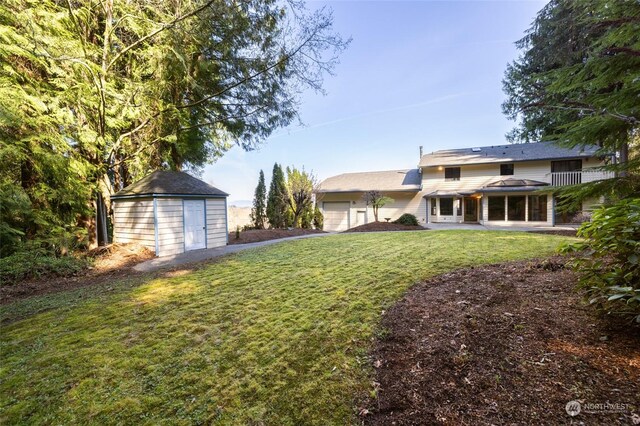 view of yard with an attached garage, a shed, and an outdoor structure