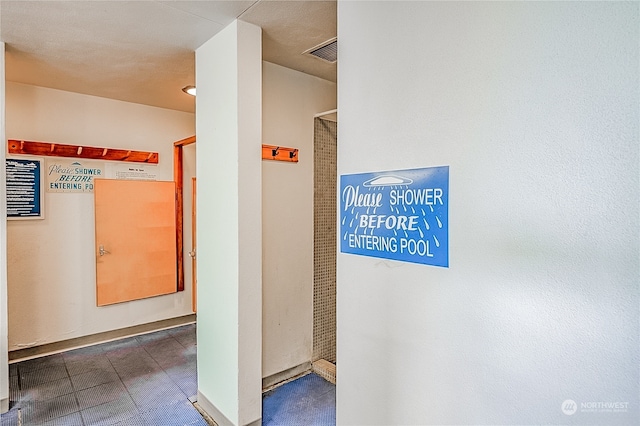 hall featuring dark tile patterned floors