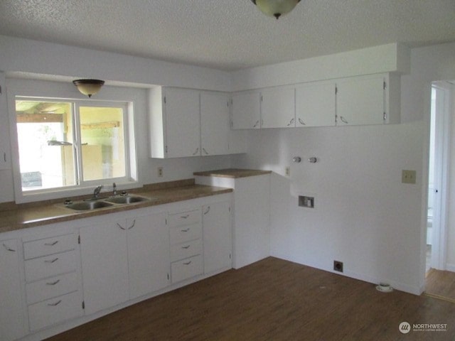 kitchen with light countertops, a sink, a textured ceiling, white cabinetry, and dark wood-style flooring