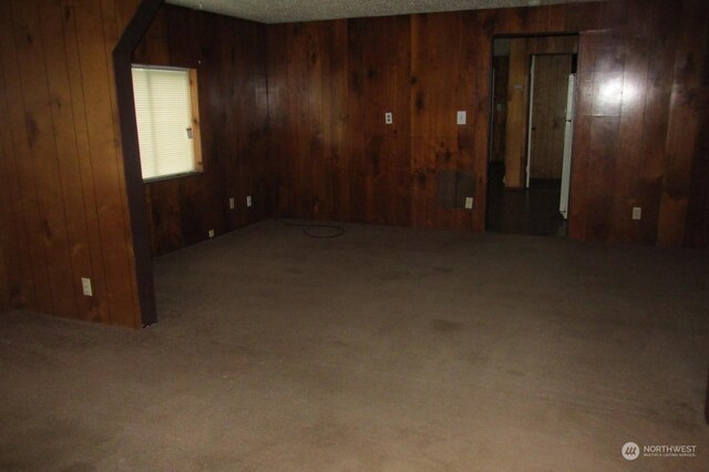 carpeted empty room with wooden walls