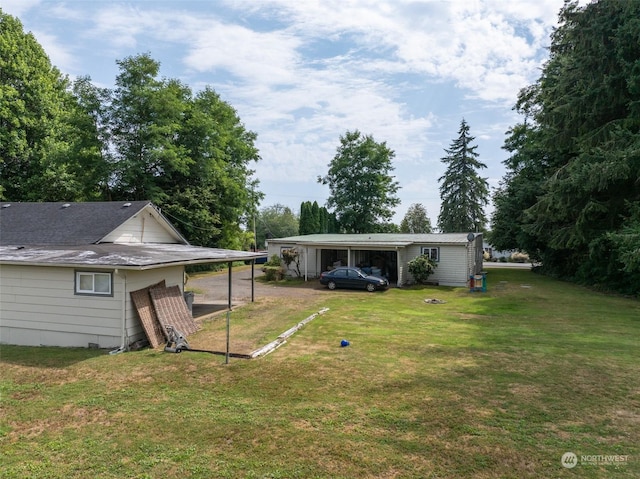 view of yard with driveway and an attached carport