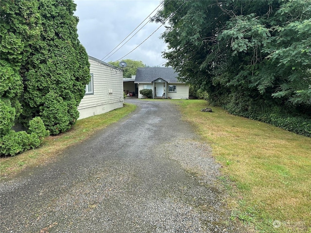 view of front of house featuring aphalt driveway and a front yard