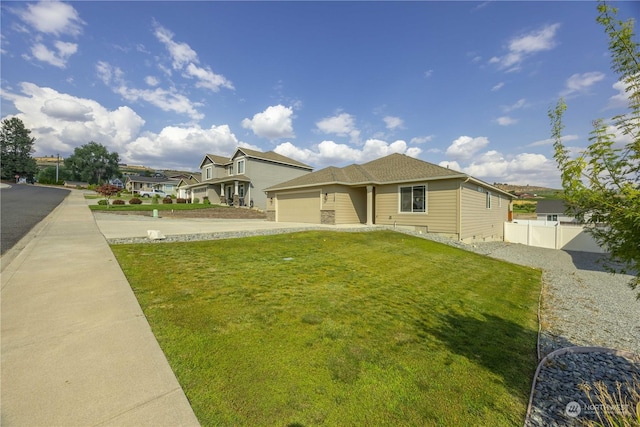 view of front of house with a garage, concrete driveway, a front yard, and fence