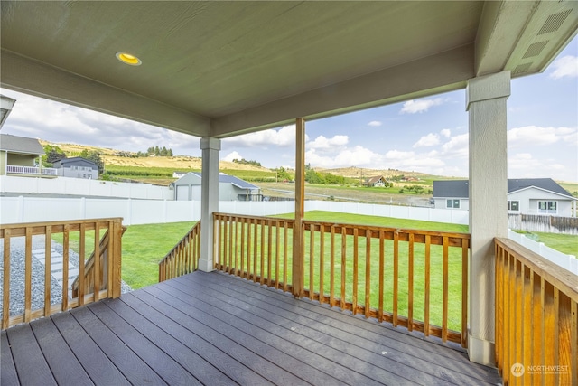 wooden terrace featuring a lawn and a water view