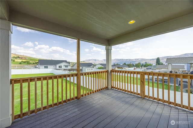 wooden terrace with a mountain view and a yard