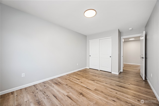 unfurnished bedroom featuring light wood-type flooring and a closet