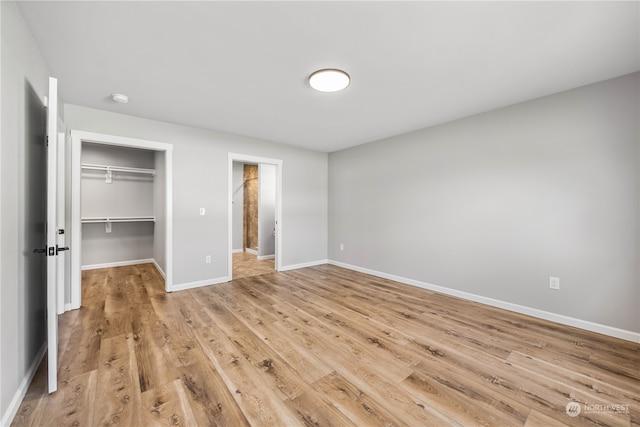 unfurnished bedroom with a closet and light wood-type flooring