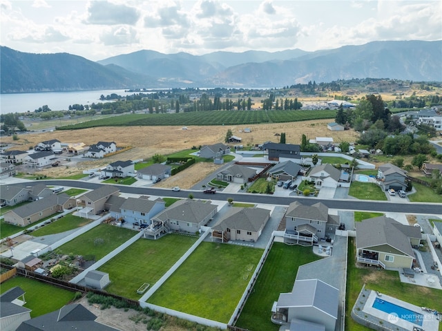 birds eye view of property with a water and mountain view