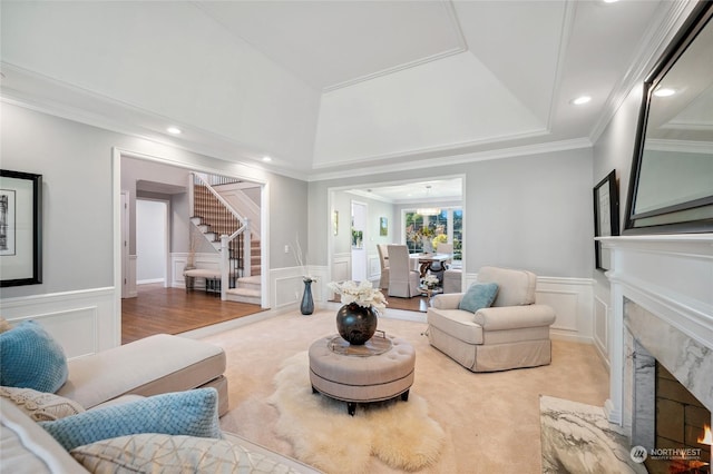 carpeted living room with recessed lighting, a decorative wall, stairway, a high end fireplace, and wainscoting