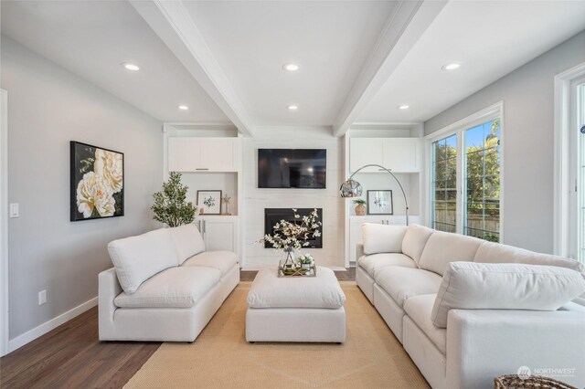 living room featuring a high end fireplace, light hardwood / wood-style flooring, and beam ceiling