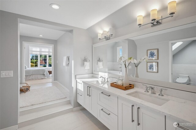 bathroom with tile patterned flooring, vaulted ceiling, toilet, and vanity