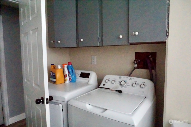 laundry room featuring washing machine and clothes dryer and cabinets