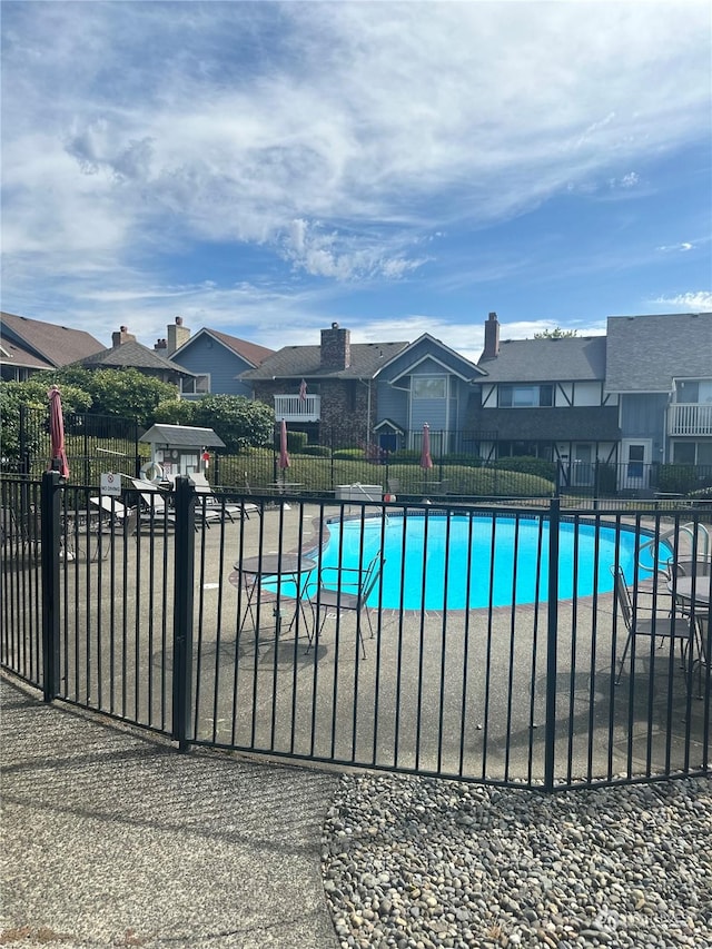 view of swimming pool with a residential view, fence, and a fenced in pool