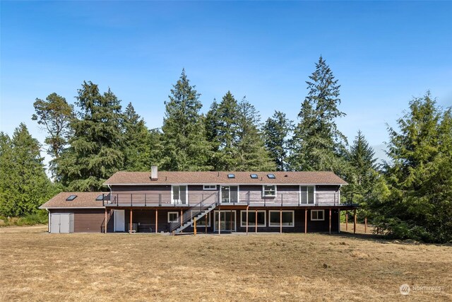 back of house featuring a deck and a lawn