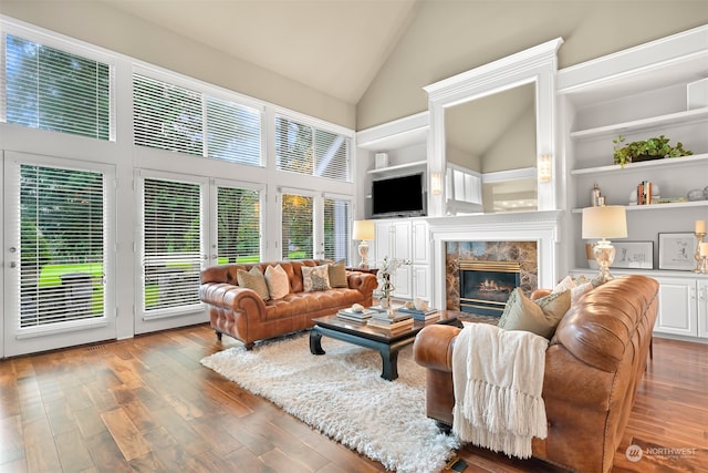 living room featuring hardwood / wood-style floors, a high end fireplace, and high vaulted ceiling