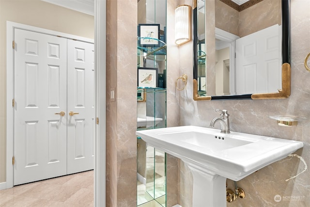 bathroom with backsplash, ornamental molding, and sink