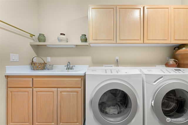 laundry area featuring washer and clothes dryer, cabinets, and sink