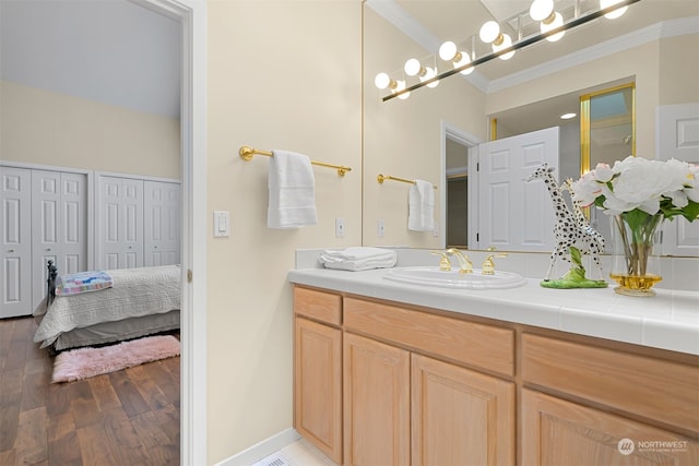 bathroom featuring vanity, wood-type flooring, and ornamental molding