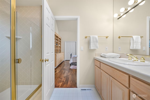 bathroom with hardwood / wood-style floors, vanity, and a shower with door