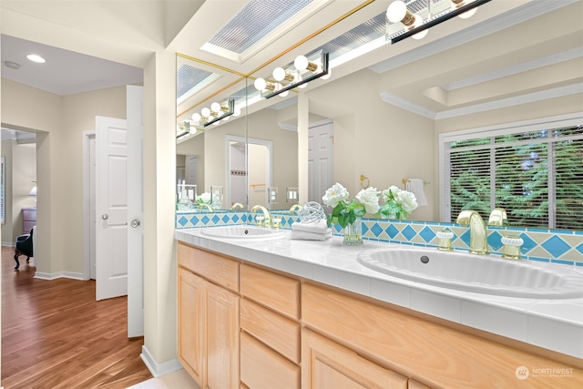 bathroom with wood-type flooring, vanity, and ornamental molding