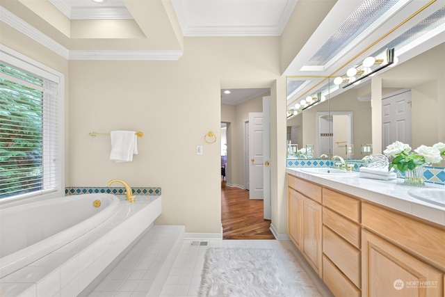 bathroom featuring tiled bath, hardwood / wood-style floors, vanity, and ornamental molding