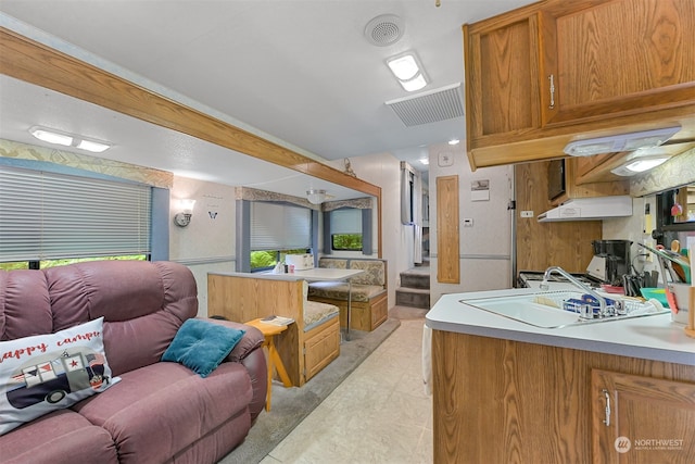 kitchen featuring sink, kitchen peninsula, and light tile patterned floors