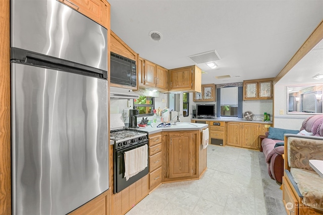 kitchen with sink, light tile patterned floors, and black appliances