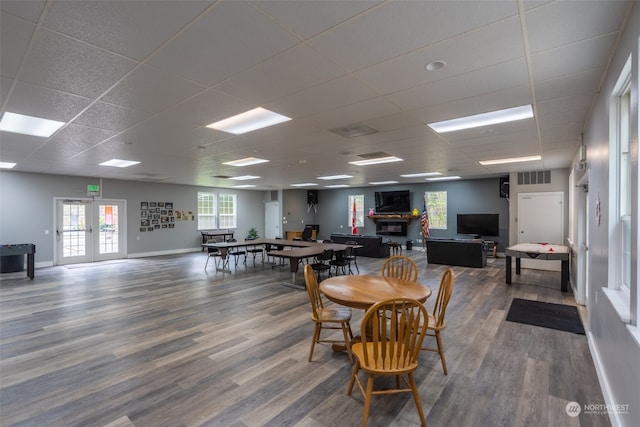 dining space featuring a drop ceiling, french doors, and wood-type flooring