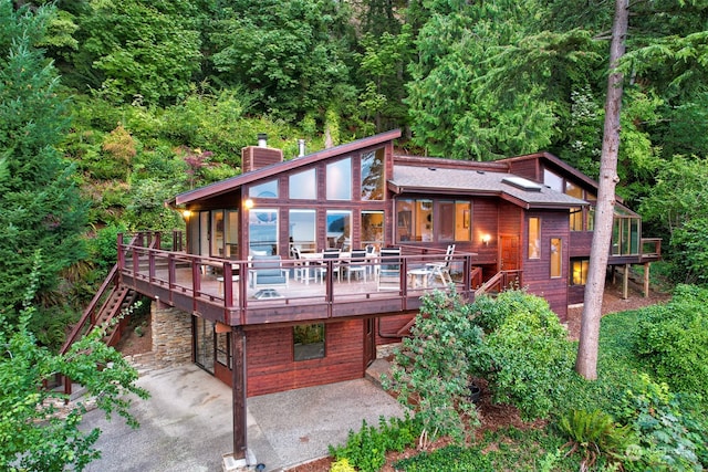 back of property featuring a wooden deck and a patio area